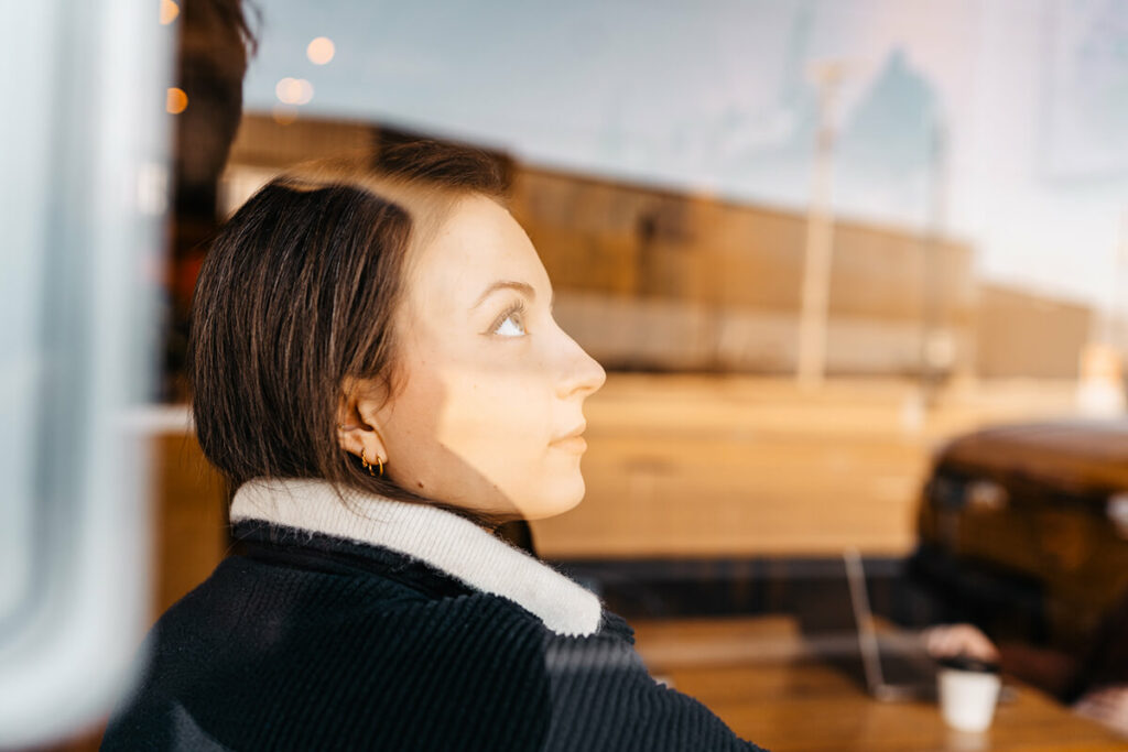 Lady sitting and looking out window of a coffee shop